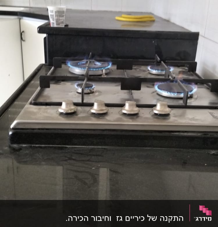 כיריים גז עם ארבעה מבערים דולקים במטבח